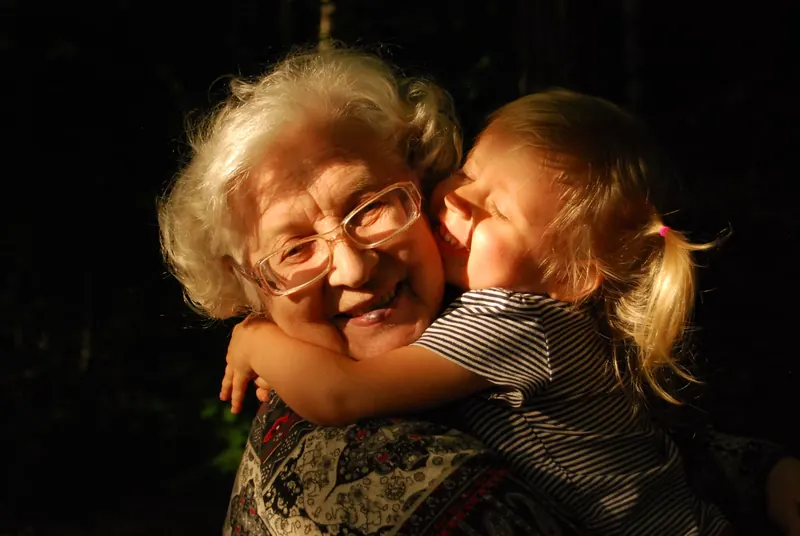 Une grand-mère et une enfant s’enlacent.